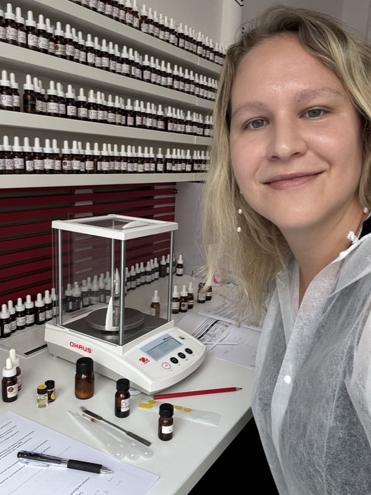Floriane Bobée devant une balance de précision, entourée des flacons de dilutions.